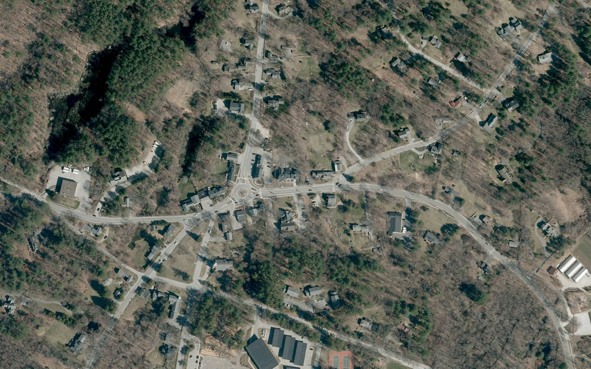 Aerial view of Carlisle Center, its historic crossroads, civic buildings, homes, and surrounding woodland